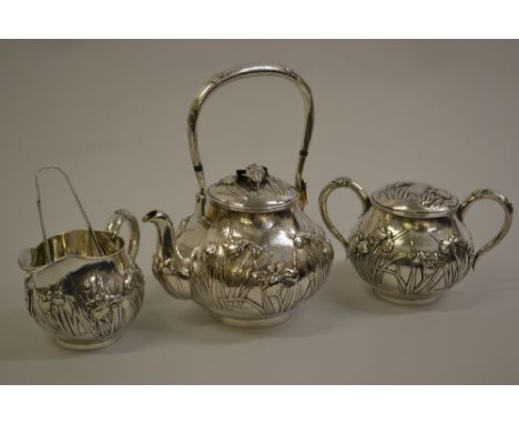 Late 19th or early 20th Century Chinese silver three piece tea service with tongs, relief moulded with irises, signed with fo