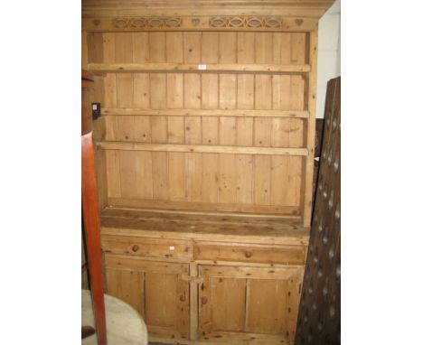 19th Century stripped pine Welsh dresser with a boarded shelf back above two drawers and two panelled doors and shaped feet