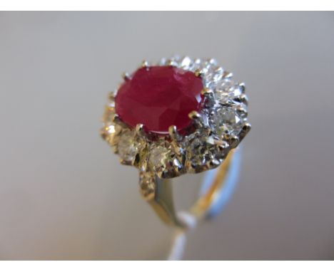 Ruby and diamond oval cluster ring, the large central oval pink ruby with diamond surround and shoulders