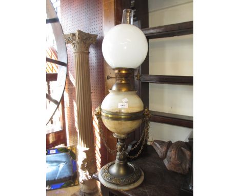 19th Century gilt metal and onyx mounted oil lamp having lion mask head handles with chain swags on a circular mounted base w