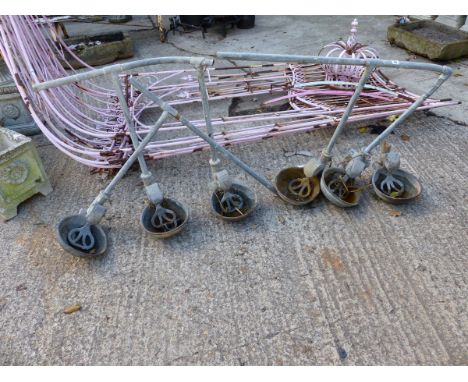 A SET OF SIX VINTAGE CAST IRON CATTLE FEEDERS.