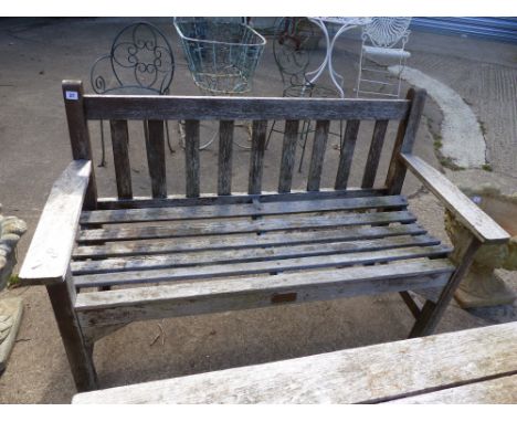A TEAK GARDEN BENCH TOGETHER WITH A SIMILAR TABLE.