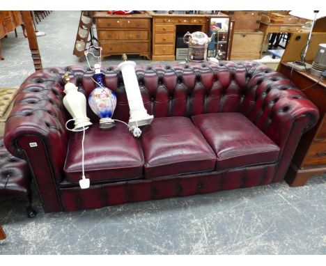 A BURGUNDY LEATHER BUTTON BACK CHESTERFIELD SOFA, AND SIMILAR FOOTSTOOL. 