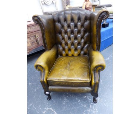 A PAIR OF GREEN LEATHER BUTTON UPHOLSTERED WING BACK ARM CHAIRS. 