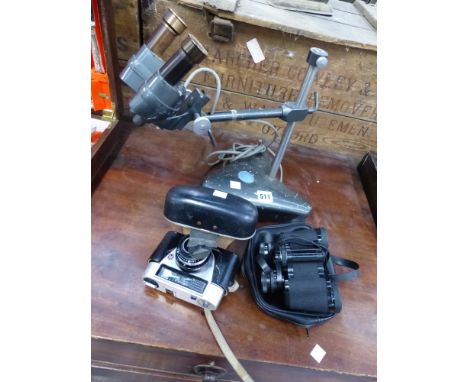 A MICROSCOPE, A PAIR OF BINOCULARS AND A CAMERA. 