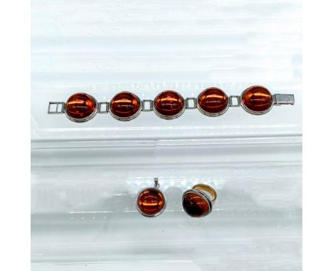 The ring band is solid 14k gold and the rest is sterling silver. Pendant is sterling silver with an amber-colored cabochon. 1