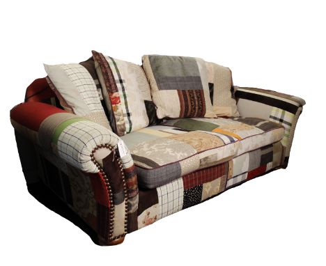 A patch work fabric two seater sofa on turned wooden feet, 225cm(w). 100cm(d)Estimates are subject to 24% Buyers Premium (inc