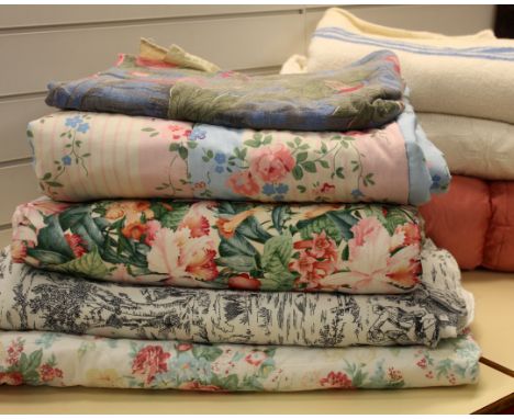 A pink floral Laura Ashley reversible quilt, a pink eiderdown, a pink floral and striped reversible to plain blue Laura Ashle