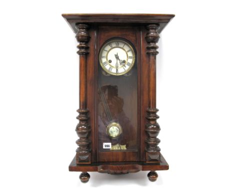 A Late XIX Century Vienna Wall Clock, the white enamel dial with Roman numerals, in a mahogany case, 63cm long.