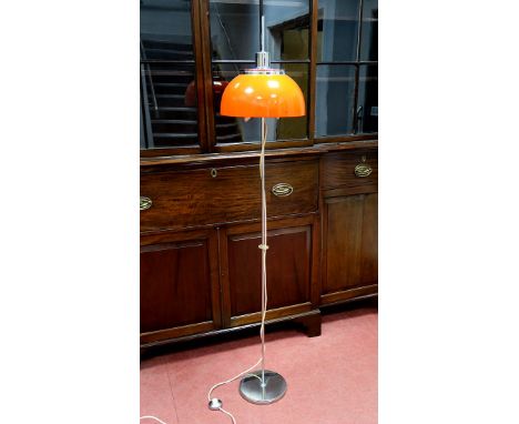 A 1970's Harvey Guzzini Floor Lamp, with adjustable tangerine plastic shade on a chrome stand and circular base, labelled, 16