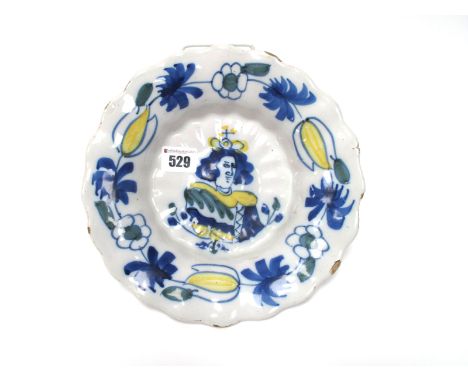 A Late XVII Century Dutch Delft Royal Commemorative Dish, of fluted circular form, painted in blue, green and yellow with a b