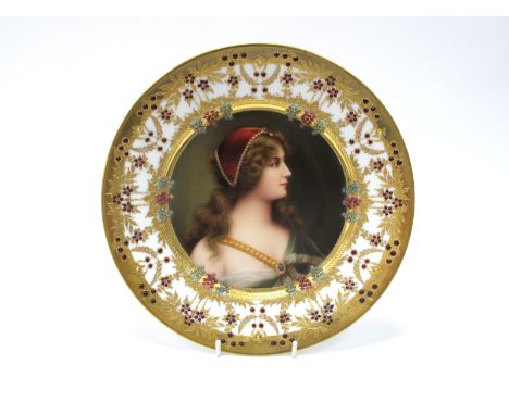 A Late XIX Century Vienna Style Porcelain Cabinet Plate, decorated with a portrait of 'Lily', wearing a green cape with gilt 