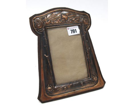 An Art Nouveau Copper Photograph Frame, of rectangular form, embossed with a galleon at sea and sinuous foliage and flower he