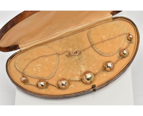 A BOXED YELLOW METAL NECKLACE, fitted with seven faceted balls, graduating in size, largest measuring 16.1mm, smallest 8.1mm,