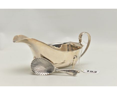 A SILVER GRAVY BOAT AND A CADDY SPOON, polished form with wavy rim and scrolling handle, raised on three cabriolet legs, hall