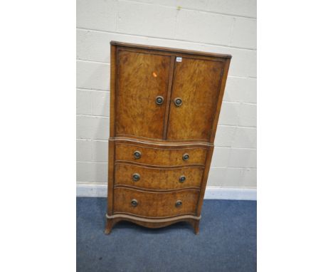 A REPRODUCTION BURR WALNUT SERPENTINE TALLBOY, with two cupboard doors enclosing a single shelf, above three graduated drawer