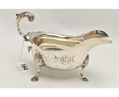 A LATE VICTORIAN SILVER GRAVY BOAT,  polished form with engraved monogram and dated 1934-1959, wavy rim with scrolling handle