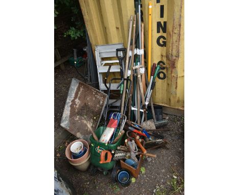 A VARIETY OF GARDEN TOOLS, to include a wheelbarrow, seed spreader, shovels, brushes, forks, ladders, a small selection of po