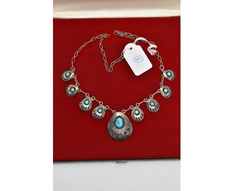 A BOXED WHITE METAL TURQUOISE NECKLACE, designed with a row of nine pierced pendants each set with turquoise cabochons, fitte