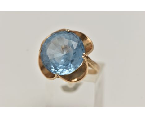 A 9CT GOLD GEM SET DRESS RING, set with a circular cut light blue stone assessed as synthetic spinel, four claw set in an ope