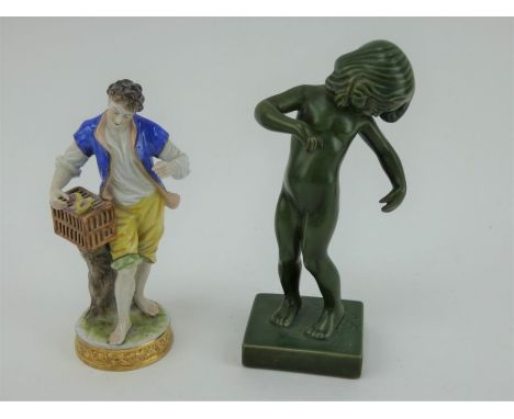 A 1930s green glazed figure 'Venus Kalipygos' by Kai Nielsen, and a Dresden style porcelain figure of a man with birdcage. Ta