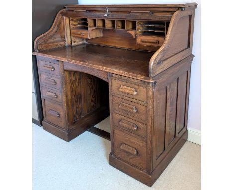 An oak Art Deco 'The Lebus Desk' s-shaped scroll top desk with fitted interior and 8 pillar drawers