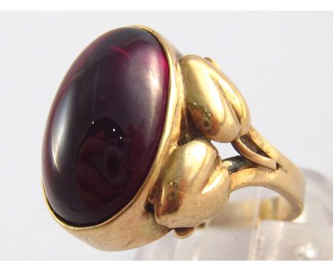 A yellow metal (tests 9 carat gold) cabochon garnet ring, stone approx 18 x 11.5mm, ring size R, 8.1 gms.
