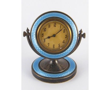 A silver boudoir clock, the circular dial framed in blue guilloche enamel and pivoting over a similarly decorated stand by A.