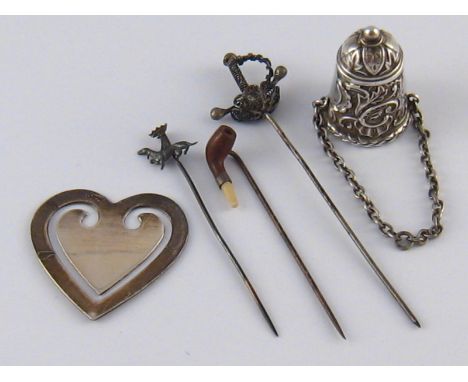 A silver chatelaine thimble holder on pendant chain, Birmingham 1900, a heart shaped page marker, marked 925, and three tiepi
