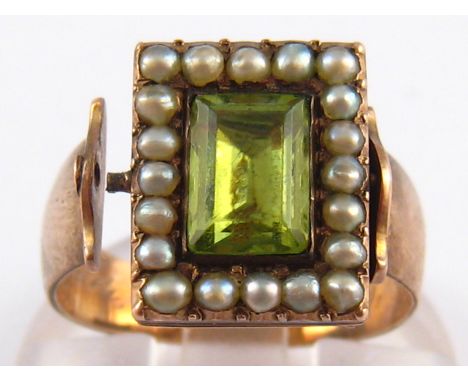 An antique peridot and seed pearl mourning ring, the reversible head with enamelled memorial verso (swivel A/F) , the shank w