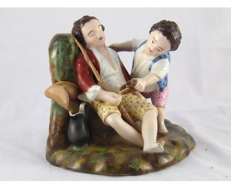 A 19th. century Russian ceramic group of a child teasing a sleeping young man, impressed Gardner mark. Ht.13cm. 