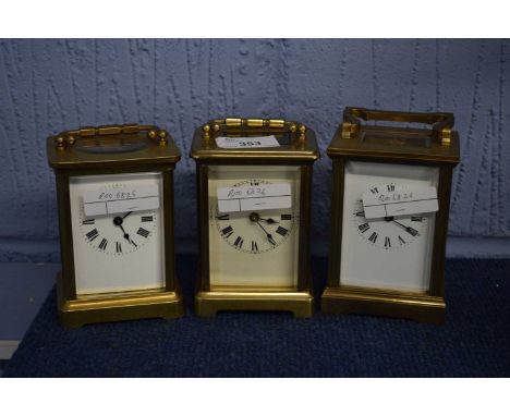 A group of three late 19th or early 20th Century carriage clocks, one with French movement, all with white enamel dials and b