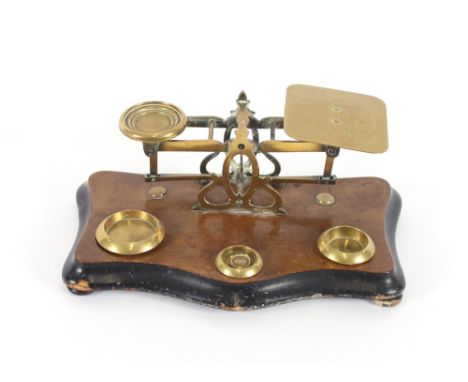 A set of Victorian brass postal scales, on shaped platform base, weights incomplete; and a circular inlaid mahogany barometer