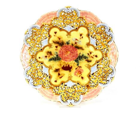 A Zsolnay Pecs wall plate, having foliate pierced decoration within a pink shell border, painted central floral panel, 32cm d