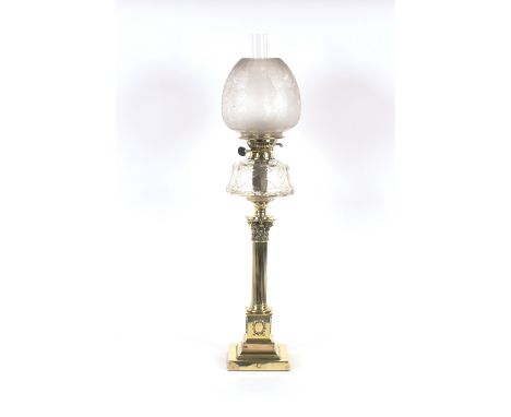 A brass Corinthian column table oil lamp,&nbsp;having cut clear glass reservoir and frosted foliate shade, 82cm high overall&