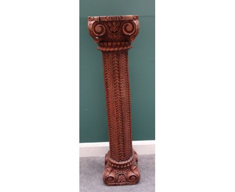 A carved pitch pine column with ionic capital and base, with scale carved body, 123cm high x 30cm wide.