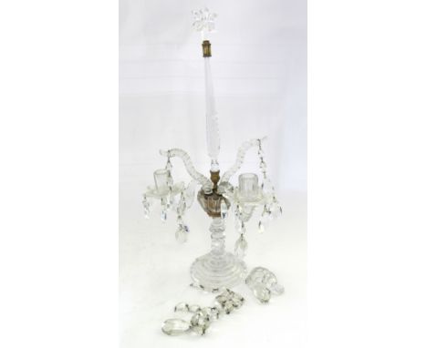 A cut glass two branch candelabra, 19th century, with 'star' finial over a tapering spire and two swan neck branches, a facet