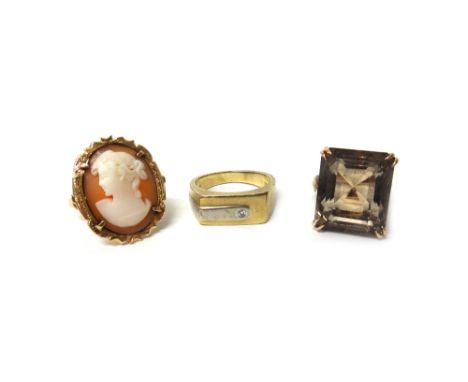 A gold ring, claw set with a rectangular step cut smoky quartz, detailed '14K', a gold ring mounted with an oval shell cameo 