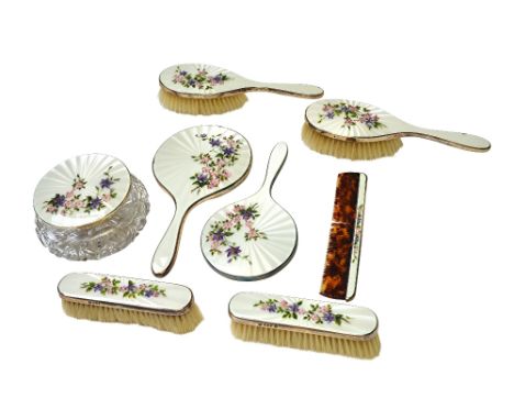 A lady's silver and enamelled eight piece composite dressing set, comprising; a large faceted glass powder bowl, two hand mir