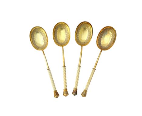 A set of four Victorian silver gilt dessert or fruit serving spoons, each with a curved oval bowl having engraved decoration,