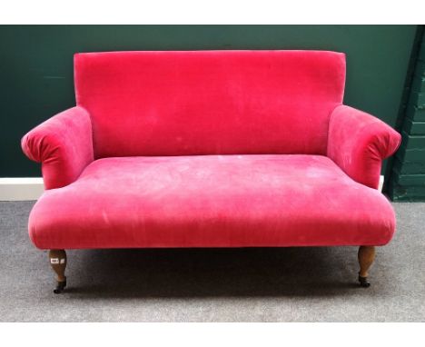 OKA;  A 20th century pink upholstered two seat sofa with roll over arms on turned oak supports, 140cm wide x 85cm high. 