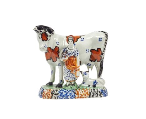 A Pratt ware model of a cow and attendant, circa 1815, with ochre and black markings, a female attendant and calf to the poly