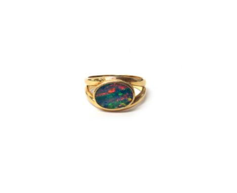 A gold and opal single stone ring, mounted with an oval opal between split shoulders, detailed 750, gross weight 4.6g ring si