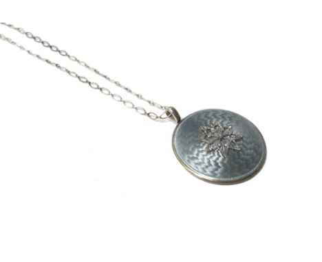 An enamelled and diamond set circular pendant, the front with an applied rose diamond set star motif, on a pale blue enamelle