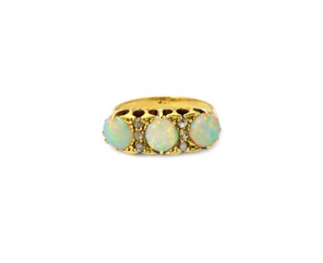 A gold, opal and diamond ring, mounted with three opals and with two rows of three rose cut diamonds mounted at intervals, ri