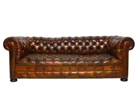 A 20th century Chesterfield sofa, with brass studded buttoned brown leather upholstery, on bun feet, 215cm wide x 75cm high. 