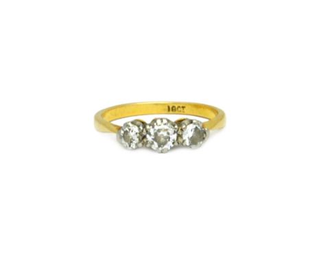 A gold and diamond set three stone ring, claw set with a row of cushion shaped diamonds and with the principle diamond mounte