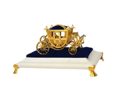 A limited edition silver gilt, cultured pearl, lapis lazuli and cabochon garnet set model of a four wheeled coach, having a p