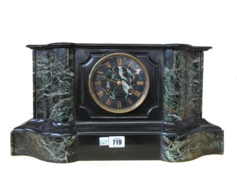 A late 19th century black slate and green marble mantel clock, of breakfront serpentine form, enclosing a French two train mo