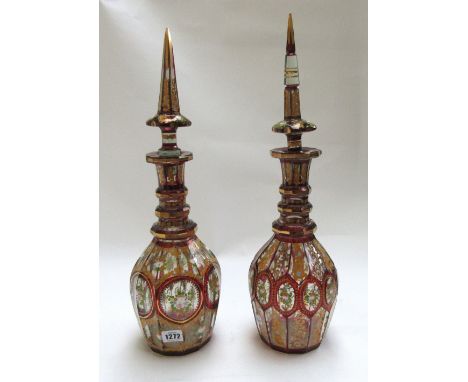 Two similar Bohemian and gilt glass decanters and stoppers, late 19th century, each with foliate enamel decoration, against a